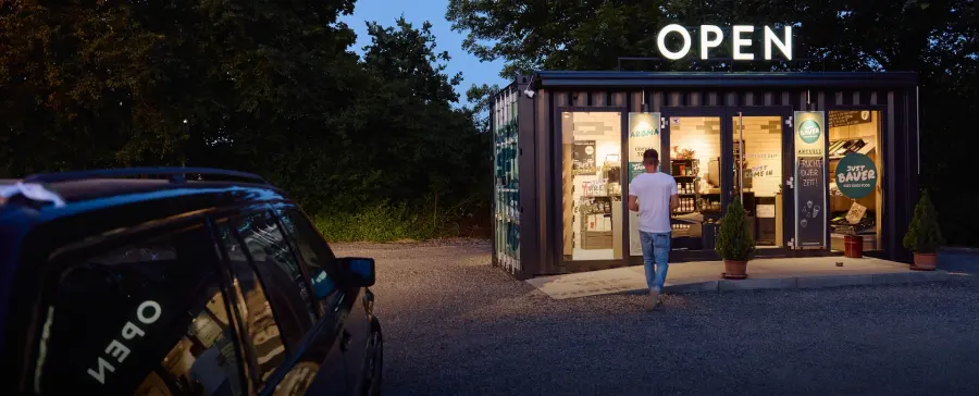 Der beleuchtete Food-Stop am Abend, das Open-Schild leuchtet