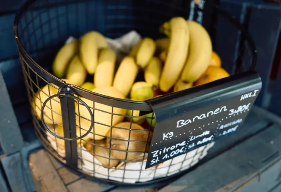 Korb mit Bananen und handgeschriebenem Preisschild